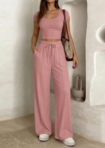 Détail d'un haut court côtelé rose et d'un pantalon large à taille haute sur un mannequin