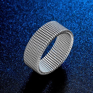 Macro shot of silver woven mesh texture on a minimalist stainless steel ring band