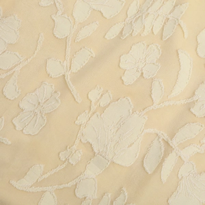 Dettaglio del tessuto jacquard beige con trame floreali 3D e raffinata lavorazione