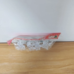 Close-up of clear acrylic angel ornaments with silver wire in holiday packaging