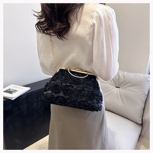 Macro view of black 3D rose flower evening bag with a vintage gold kiss lock and chain