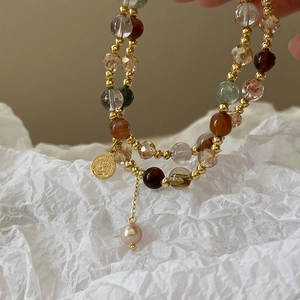 Close-up of double-layer beaded bracelet with Elizabeth coin and pink pearl charm