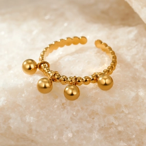 Detailed macro view of 18k gold beaded open ring with four polished spherical charms