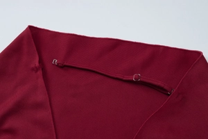 Close-up of wine red dress featuring adjustable straps and silver metal buckles