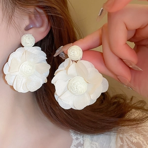 Resort style white raffia lace flower earrings worn on model for a sweet aesthetic look