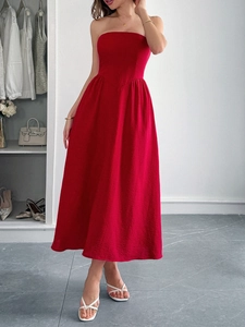 Detail of red strapless A-line maxi dress on model in clean dressing room setting