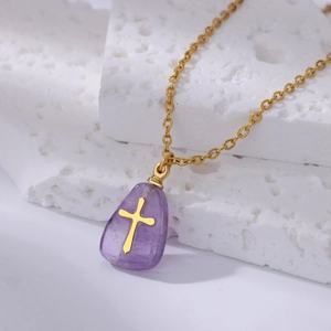 Detail of a purple teardrop pendant with golden cross inlay on a fine gold chain