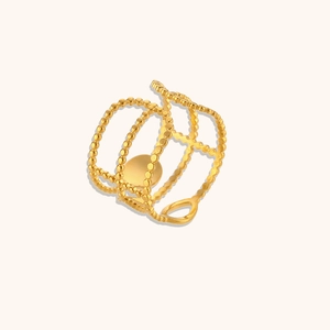 Macro detail of gold-plated triple-layer beaded ring featuring sun and moon design