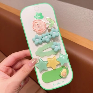 Detail showing mint green and yellow acrylic hair clips set with cute floral patterns