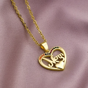 Detail of gold heart 'Mom' necklace with colorful zircon stones on purple fabric