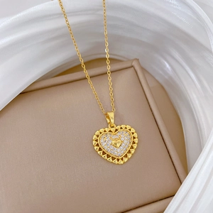 Detailed macro view of gold hollow heart pendant with sparkling crystals on silk fabric