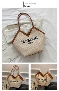Detail of woven straw tote bag featuring brown leather straps and black embroidered logo