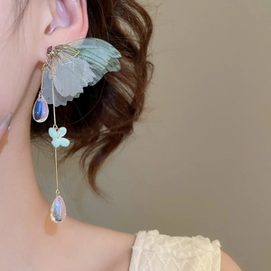 Close-up of elegant tassel earring featuring translucent wings and iridescent pendants