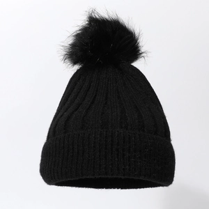 Detailed view of the thick ribbed knit texture and soft faux fur pom-pom on the black beanie
