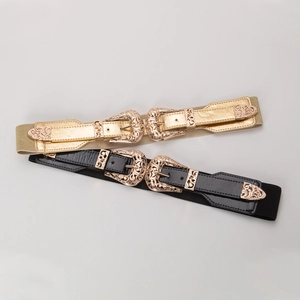 Detail of western style belts with ornate floral metal buckles and elastic fabric