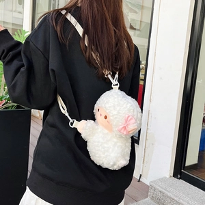 Cute white plush sheep crossbody bag with pink bow accessory worn by a girl on the street