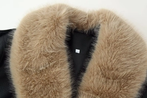 Detail of plush camel faux fur collar on black leather jacket with soft lining texture