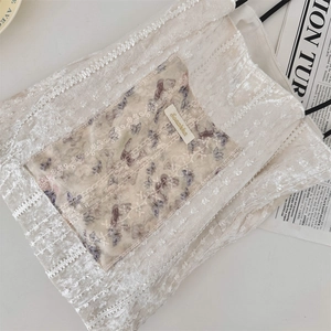 Detail of off-white canvas bag with lace trim and floral butterfly embroidery