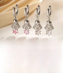 Detailed view of silver hoop earrings featuring badminton shuttlecock charms with pink zircons