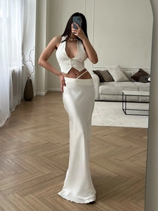 Détail d'un élégant ensemble deux pièces en satin blanc avec gilet décolleté en V et jupe