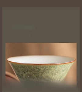 Macro shot of green starry glaze ceramic tea cup with detailed gold rim craftsmanship
