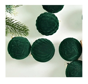 Detail of dark green velvet Christmas balls with embossed patterns and gold metal loops