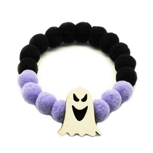 Detail of Halloween pet collar with purple and black pom-poms and a cute ghost charm