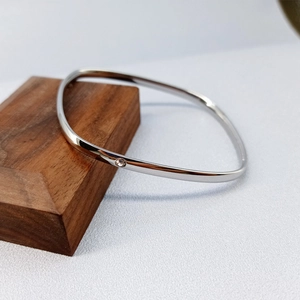 Minimalist square titanium steel silver bangle with micro-set zircon on wooden block