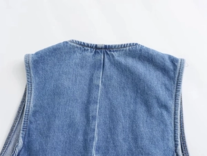 Dettaglio del gilet in denim blu con cuciture e trama del tessuto sul colletto posteriore
