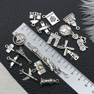 Macro detail of vintage silver travel charms featuring passport and airplane on black leather