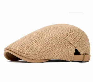Detail of camel knitted newsboy cap featuring textured weave and adjustable metal buckle