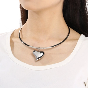 Polished silver stainless steel choker with hollow heart pendant worn by a model