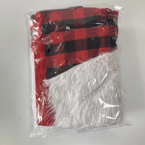 Détail du sac cadeau de Noël à carreaux rouges et noirs dans son emballage plastique