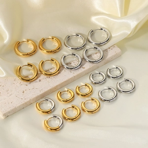 Polished chunky titanium steel hoop earrings in gold and silver set on silk and stone