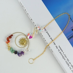 Detail of sun catcher featuring golden sun pendant, colorful chakra stones and crystal ball