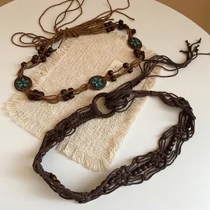 Bohemian woven waist chains with ethnic beads and metal charms on rustic fabric
