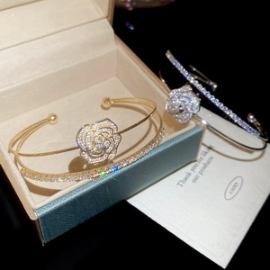 Detailed macro view of double-layer zircon flower bangles in gold and silver finish