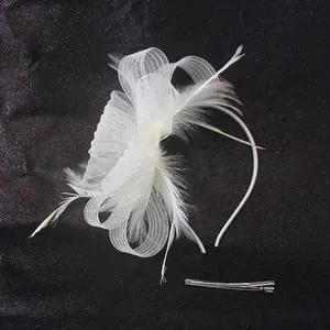 Detail of white fascinator featuring mesh bow, feathers, and silver metal hair clip