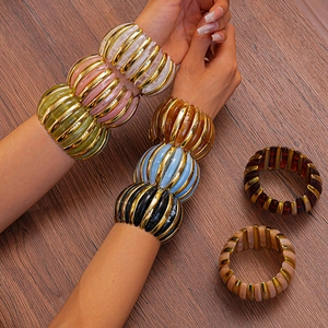 Detailed close-up of acrylic beaded stretch bracelets in assorted colors on a wood surface