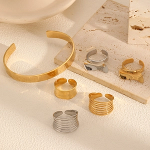 Schickes Schmuckset aus 18 Karat Gold und Edelstahl mit Manschetten und verstellbaren Ringen
