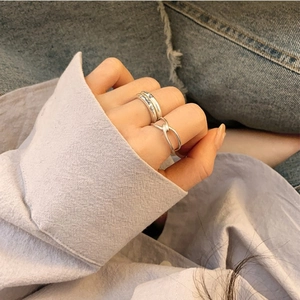 925 silver knot ring set with smile engraving shown on hand against denim background