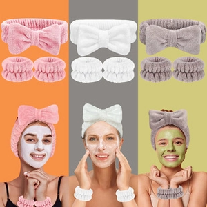Macro detail of plush bow headband and wristbands set in pink, white, and grey colors