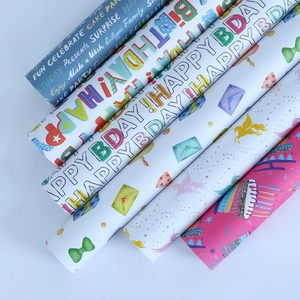 Five rolls of colorful birthday gift wrapping paper with unicorns and celebratory text