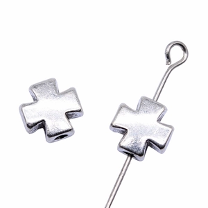 Silver metal cross beads with hole design for DIY jewelry making on white background