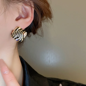 Close-up of vintage zebra stripe square earrings with rhinestones on a female model