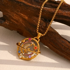 Macro view of 18K gold plated compass pendant with colorful crystals and moon star motifs