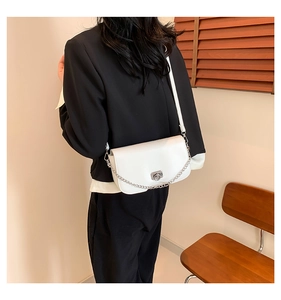 Detail of white minimalist crossbody bag with silver chain and metal twist lock detail