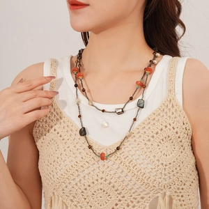 Détail du collier ethnique multicouche avec perles en bois et touches turquoise