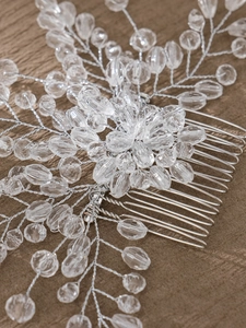 Close-up of handmade bridal hair comb with silver wire, crystal beads, and pearls