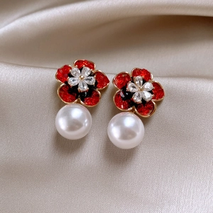 Elegant gold earrings featuring red crystal flowers and round white pearl pendants
